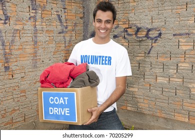 Happy Hispanic Volunteer With Coat Drive Donation Box