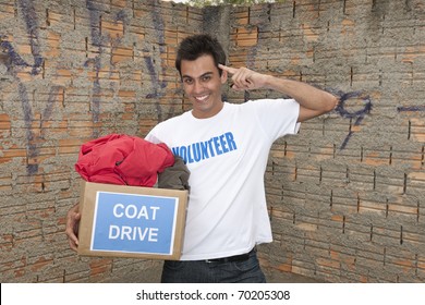 Happy Hispanic Volunteer With Coat Drive Donation Box