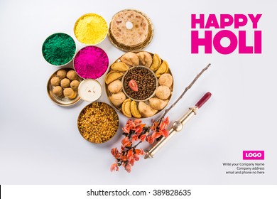 Happy Holi greeting card designed showing Indian traditional sweet and salty food, flowers and powder colours arranged over white background or clay. Selective focus