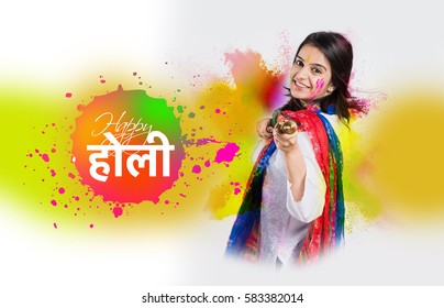 Happy Holi greeting card showing beautiful indian girl playing or spraying colours with pichkari over white background