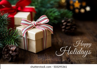 Happy Boxing Day Messages, Wishes, Quotes, And Images 62 Happy holidays greeting. Wrapped Christmas gifts on dark rustic wooden table with pine cones and fir branches.