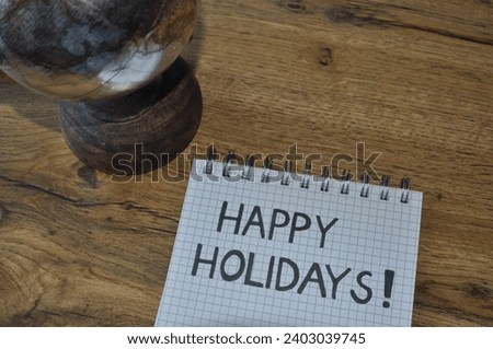 happy holidays write on the woodenbackground next to globus - traveling backgrund 