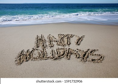 Happy Holidays written in the beach sand. The words Happy Holidays written by the ocean in the sand. 
  - Powered by Shutterstock