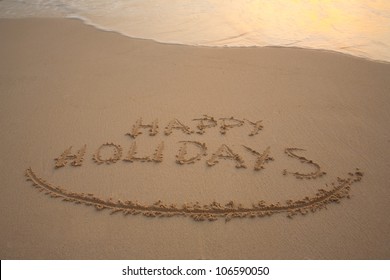 Happy Holidays Written In The Sandy Beach