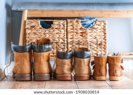Happy home family concept. Small and big yellow boots together. Leather tourist boots. Shoes of father, mother and a child