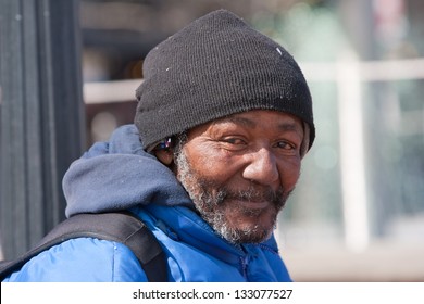 Happy homeless african american man outdoors during the day.