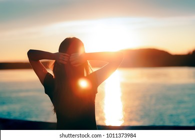 Happy Hopeful Woman Looking At The Sunset By The Sea. Silhouette Of A Dreamer Girl Looking Hopeful At The Horizon
