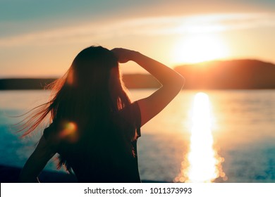 Happy Hopeful Woman Looking at the Sunset by the Sea. Silhouette of a dreamer girl looking hopeful at the horizon
 - Shutterstock ID 1011373993