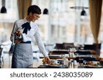 Happy hotel waitress serving breakfast at the tables in a restaurant. Copy space. 