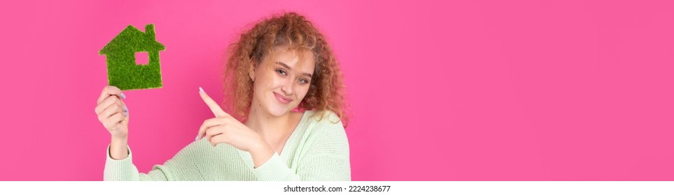 Happy House Buyer. A Young Girl Holds A Model Of A Green House In Her Hands. The Concept Of Green Energy, Ecology.