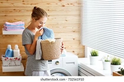 A Happy Housewife Woman In Laundry Room With Washing Machine  
