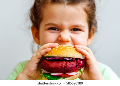 Happy Hungry Child (girl) Eating Healthy Vegan Burger.