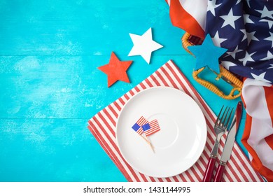 Happy Independence Day, 4th Of July Celebration Concept With Picnic Basket, Plate And USA Flag On Wooden Background. Top View From Above