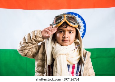 Happy Indian Or Asian Boy Kid Flying A Toy Metal Airplane Or Saluting Against Indian Flag Background - Kid And Flying For Country