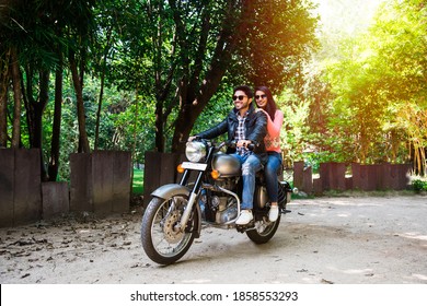 Happy Indian Asian Couple Riding On Motorbike Or Motorcycle On Forest Roads