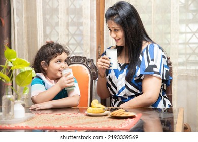 Happy Indian Asian Mother And Cute Little Daughter Drink Milk Together To Get Calcium And Protein. Having Breakfast. Happy Family. Healthy Diet,