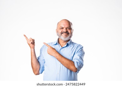 Happy Indian asian retired senior old man pointing, advertising, presenting blank copy space - Powered by Shutterstock