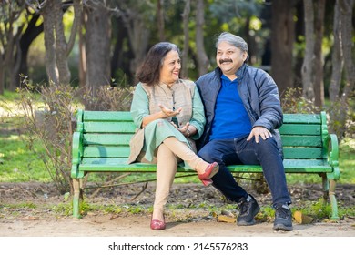 Happy Indian or asian senior couple talking laughing while sitting on the bench, Old man and woman relaxing at park spend time together, relationship and people concept.