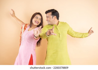 Happy indian couple dancing together wearing traditional or ethnic cloths isolated on studio background, Man and woman celebrating diwali festival, onlie sale, enjoying life concept, - Powered by Shutterstock