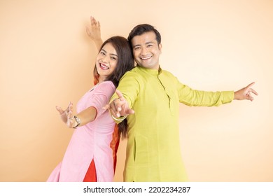 Happy indian couple dancing together wearing traditional or ethnic cloths isolated on studio background, Man and woman celebrating diwali festival, online shopping deal, enjoying life concept, - Powered by Shutterstock