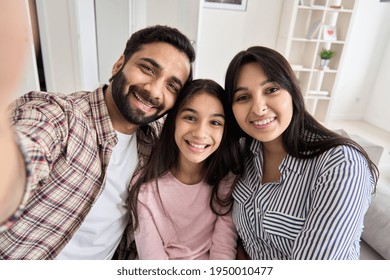 Happy Indian Couple And Teen Daughter Taking Selfie Looking At Phone Camera. Smiling Family With Child Girl Making Picture Or Having Virtual Call Meeting, Shooting Vlog On Modern Smartphone At Home.