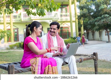 Happy Indian couple using laptop on traditional bed at village - Shutterstock ID 1886261266