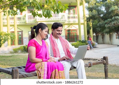 Happy Indian couple using laptop on traditional bed at village - Shutterstock ID 1886261272