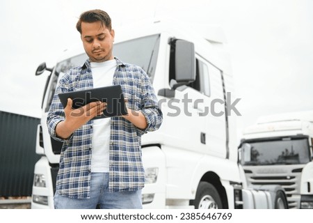 Happy indian courier using tablet in the van . High quality photo.