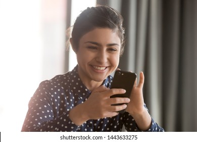 Happy Indian Ethnic Business Woman Using Smartphone At Home Office, Smiling Hindu Girl Having Fun With Cell Phone Texting Sms Play Mobile Games Using Apps For Business Or Entertainment Concept