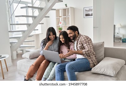 Happy indian family with child daughter having fun using laptop computer at home. Smiling parents and teen kid daughter laughing having virtual video call meeting, watching funny online tv sit on sofa