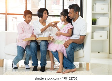 happy indian family eating pizza at home

 - Powered by Shutterstock