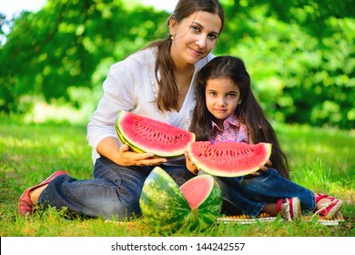 Happy Indian Family Eating Watermelon In Park