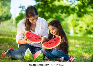 Happy Indian Family Eating Watermelon In Park