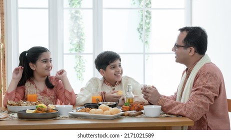 Happy Indian family enjoy eating food with hands, South Asian father and children wear traditional clothes, sitting at dining table at home together. Indian culture lifestyle. - Shutterstock ID 2171021589