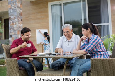 Happy Indian Family Enjoying Media Content On Digital Tablet