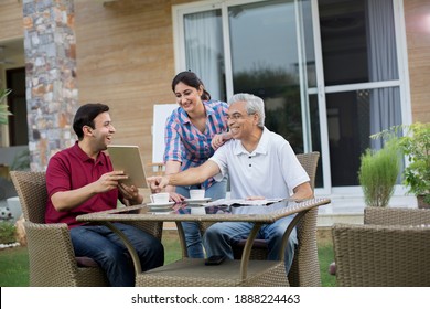 Happy Indian Family Enjoying Media Content On Digital Tablet