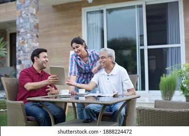 Happy Indian Family Enjoying Media Content On Digital Tablet