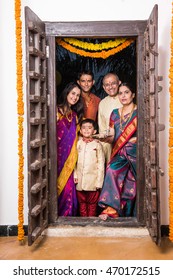 Happy Indian Family Entering House With Puja Thali Through Old Antique Door - Griha Pravesh