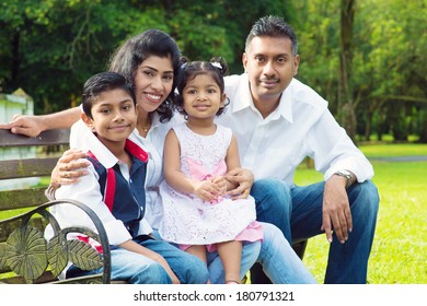 Happy Indian Family At Outdoor Park. Candid Portrait Of Parents And Children Having Fun At Garden Park.