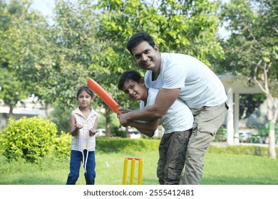 happy indian family playing cricket in park. father teaching his son to playing cricket at playground. concept family bonding and fatherhood. - Powered by Shutterstock