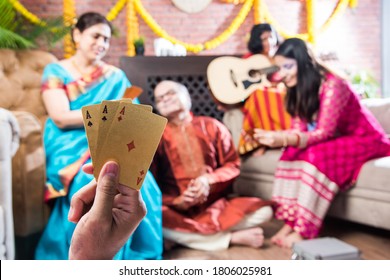 Happy Indian Family Playing Teen Patti Or Three Cards Game On Diwali Festival Night In Traditional Wear At Home