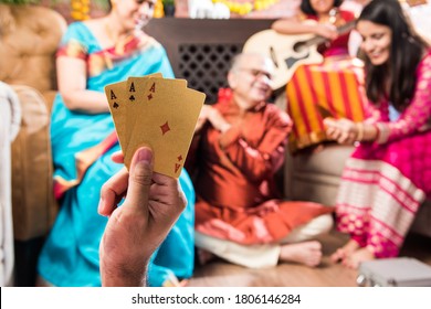 Happy Indian Family Playing Teen Patti Or Three Cards Game On Diwali Festival Night In Traditional Wear At Home