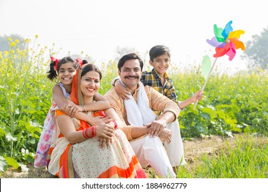 Happy Indian family standing in mustard agricultural field