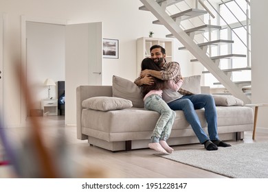 Happy Indian Family Teen Child Daughter Hugging Dad Bonding Relaxing On Sofa At Home. Young Daddy Embracing Teenage Kid Girl, Cuddling Together On Couch Enjoying Tender Moments Of Love On Fathers Day.