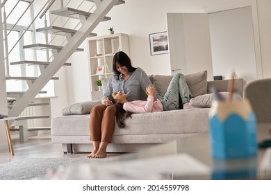 Happy Indian Family Teen Child Daughter And Mother Bonding Relaxing On Sofa At Home. Young Mum Talking To Teenage Kid Girl, Cuddling Together On Couch Enjoying Tender Moments Of Love In Living Room.