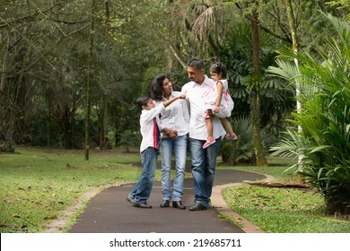 Happy Indian Family Walking Outdoor In The Park