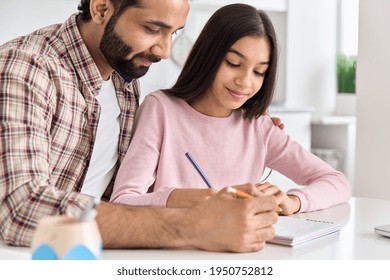 Happy Indian Father Helping School Child Teen Daughter Studying At Home. Young Caring Dad Explaining Kid Teenage Daughter Learning In Kitchen Together, Checking Homework. Homeschooling, Close Up View.