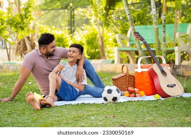 Happy indian father with son spending time together at picnic park during weekend holidays - concept of family bonding, Happy memories and outdoor fun. - Powered by Shutterstock