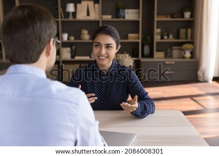 Happy Indian female client consulting male business professional, lawyer, financial expert, talking to manager, asking advice. Job candidate, new employee meeting employee for job interview