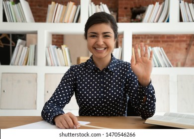 Happy indian female student looking at camera, waving hello, greeting. Smiling cheerful young intern holding interview work call with potential employer, recording self-introduction video in library. - Shutterstock ID 1470546266
